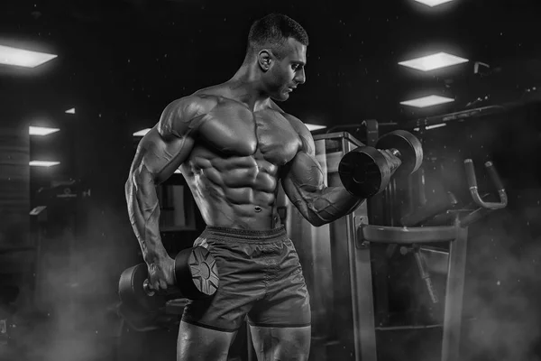 Mann im Fitnessstudio. muskulöser Bodybuilder, der Übungen mit Barbel macht — Stockfoto