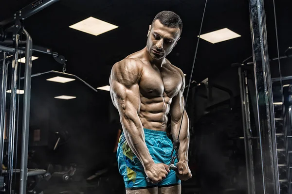 Uomo muscolare che lavora in palestra facendo esercizi a tricipiti, stro — Foto Stock