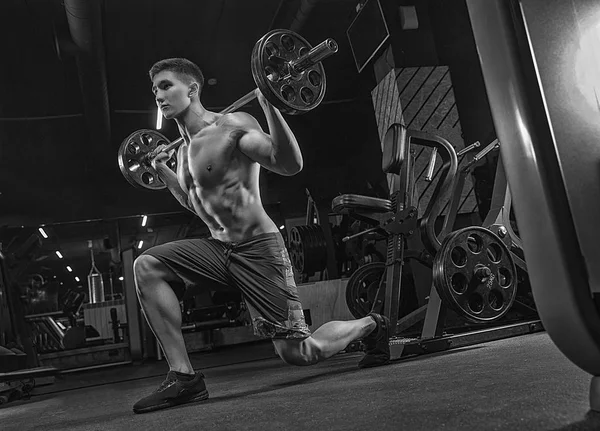 A close black-and-white photograph, a bodybuilder athlete, train