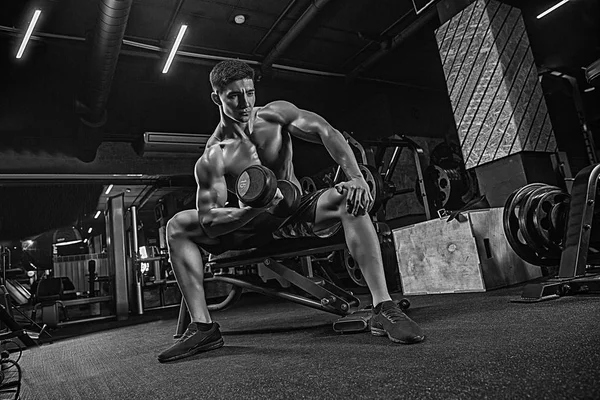 Jovem muscular desportista musculação halterofilista no ginásio em — Fotografia de Stock