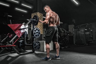 Genç yakışıklı erkek atlet vücut geliştirmeci halterci Exer yapıyor,