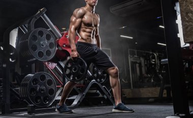 Kaslı adam spor salonunda, dumbbells ile vücut geliştiricisi. Güçlü erkek nak