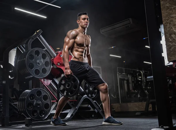 Uomo muscoloso con manubri in palestra, culturista. Forte maschio nak — Foto Stock