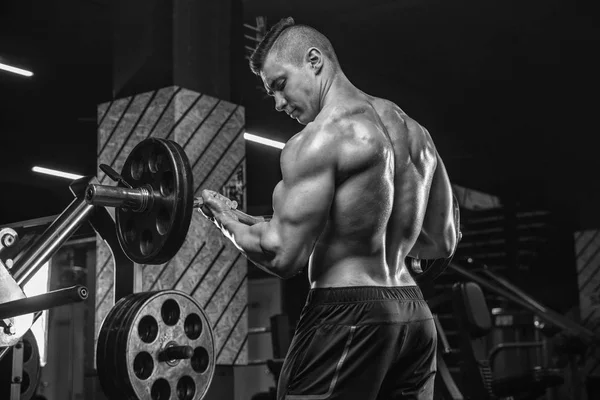 Un jeune bodybuilder masculin fait des exercices avec des équipements sportifs, m — Photo