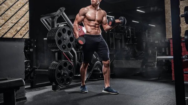 Jovem bonito atleta masculino fisiculturista halterofilista, fazendo exer — Fotografia de Stock