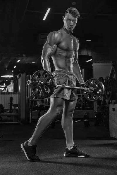 Bodybuilder che lavora con i pesi dei campanelli in palestra — Foto Stock