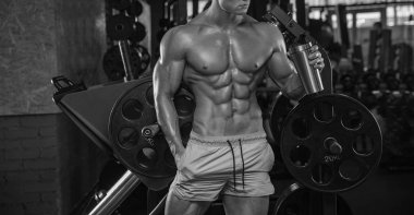 adam vücut geliştirmeci yorgun spor salonunda oturup ve sportif beslenme içecek - 