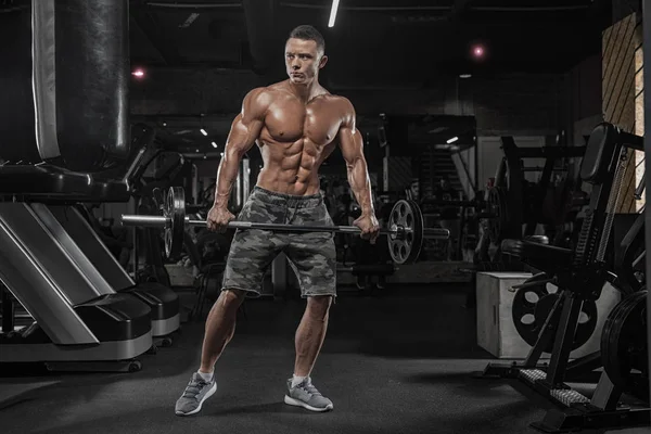 Hombre guapo con grandes músculos, posando en la cámara en el gimnasio — Foto de Stock