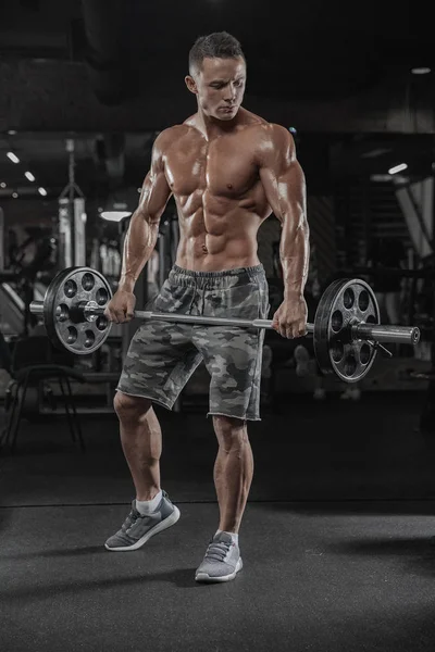 Pria berotot yang bekerja di gym melakukan latihan dengan dumbbells — Stok Foto