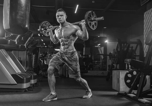 Musculaire man uit te werken in de sportschool doen oefeningen met halters — Stockfoto