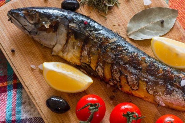 Peixe-cavala em uma tábua de madeira com tomates e ervas — Fotografia de Stock