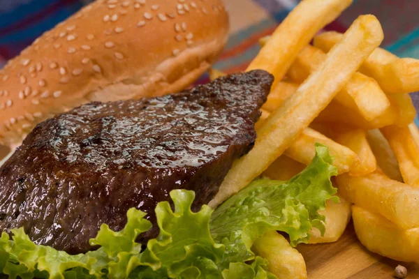 Izgara biftek, patates kızartması ve sebze.