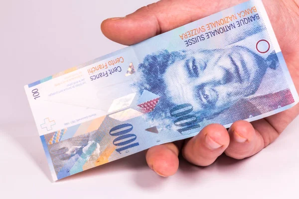 Мужчина держит в руке швейцарскую банкноту крупным планом. — стоковое фото