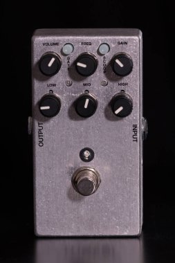 Siyah arkaplan üzerindeki gitarın metalik overdrive efektinin ön görünümü