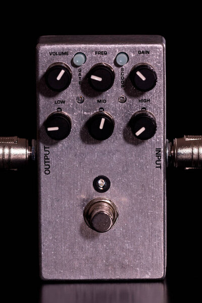 Front view of a metallic guitar effect with the included guitar cables on a black background