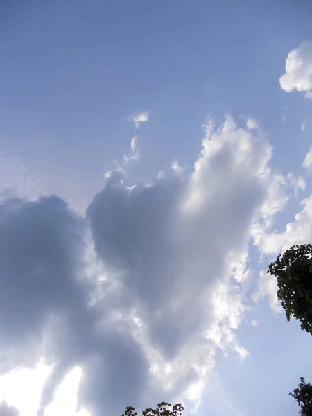 Nubes como un corazón y rayos del sol rompiendo a través de ellos — Foto de Stock