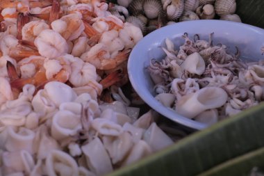 Bir gıda dükkanında haşlanmış karides, midye ve mürekkep balığı sergileniyor.