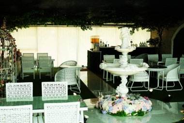 Romantik çeşme ve öğle yemeği için beyaz koltuklar.