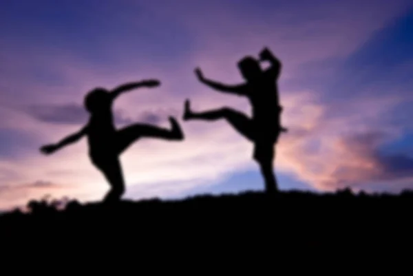 Blure silhouet gelukkig springen tegen mooi in de zonsondergang — Stockfoto