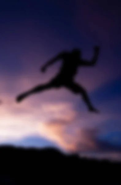 Blure Silhouette happy jumping against beautiful in sunset — Stock Photo, Image