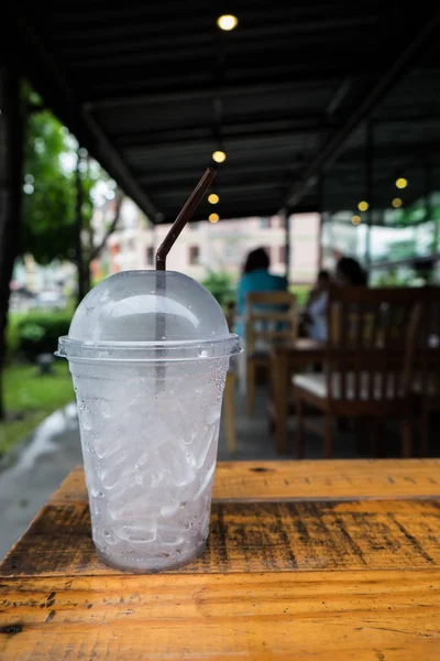 Um copo de cubos de gelo em madeira — Fotografia de Stock