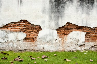 Kırmızı tuğla duvar yeşil çim döşeme ile kırık