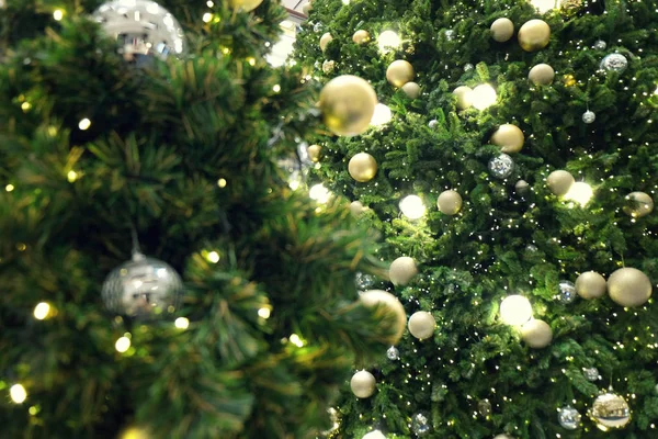Geschmückter Weihnachtsbaum auf verschwommenem, glitzerndem Hintergrund — Stockfoto