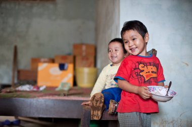 Pakse Laos 'un evinde oturan kimliği belirsiz Laos adında küçük bir çocuk.