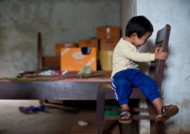 Pakse Laos 'un evinde oturan kimliği belirsiz Laos adında küçük bir çocuk.