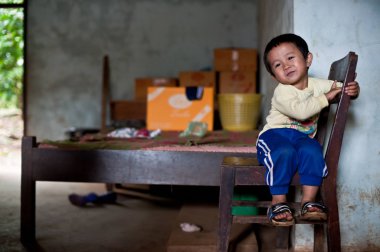 Pakse Laos 'un evinde oturan kimliği belirsiz Laos adında küçük bir çocuk.