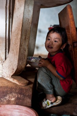 Pakse Laos 'un evinde oturan kimliği belirsiz Laos adında küçük bir çocuk.