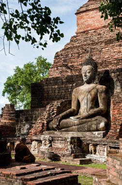 Budha 'nın önünde meditasyon yapan bir keşiş Sukhothai' de büyük bir heykel yapıyor.,