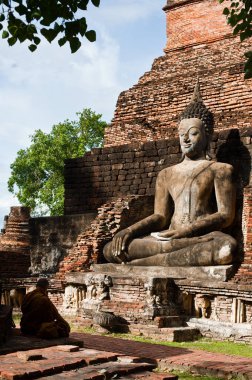 Budha 'nın önünde meditasyon yapan bir keşiş Sukhothai' de büyük bir heykel yapıyor.,