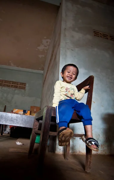 An unidentified Laos little boy sitting eating in the house of PAKSE, LAOS — Stock Photo, Image