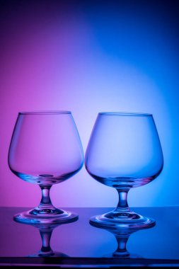 Renkli arka planda iki cam bardak.