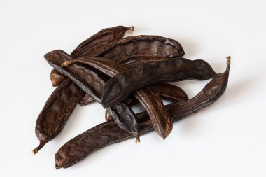 Beyaz bir zemin üzerinde keçiboynuzu meyve kabukları izole