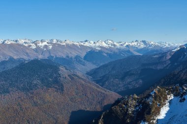 Kafkas Dağları 'nın karlı zirveleri arka planda mavi gökyüzü, arka planda paraglider, Krasnaya Polyana, seyahat kavramı.