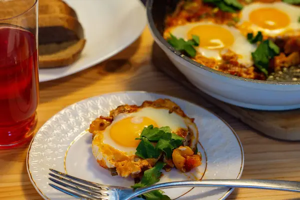 Sıcak Shakshuka domateslerinde tatlı biberli yumurtalarda ve otlarda