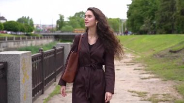 Kafkasyalı genç bir kız, tıbbi maskesiz ve eldivensiz, 19. karantina döneminde sokaklarda yürüyor. Sol tarafa bakan güzel bir kadının yaşam tarzı. Seyahat acentesi için dikey fotoğraf reklamı