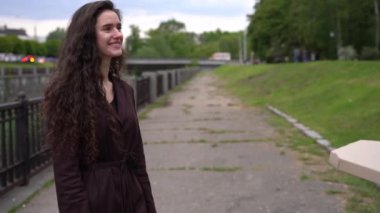 Pizzacıdan yemek servisi. Yemeği götür. Kız kuryeden pizza kutuları alıyor ve gülümsüyor. Pizza teslimatı reklamı. Güvenli fast food teslimatı.