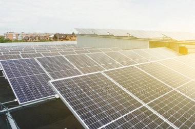 Yerdeki güneş panelleri sağ tarafta güneş ışığıyla parlıyor. Alternatif güneş enerjisi santrali. Gezegenin sürdürülebilirliği. Ev için yeşil enerji. Mavi elektrik modülleri yerde duruyor.