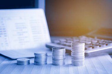 Hesap makineli para yığınları ve mavi filtreli hesap defteri arkaplanı