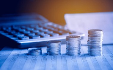 Hesap makinesi ve hesap defteri arkaplanı olan para yığınları