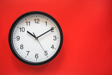 Kopya alanı ile kırmızı arkaplan üzerinde klasik siyah beyaz saat 