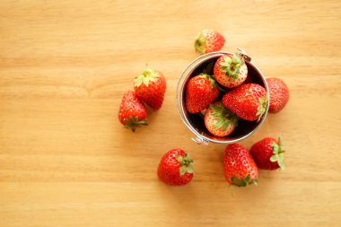 Küçük paslanmaz çelik su kovası içinde taze çilek. 