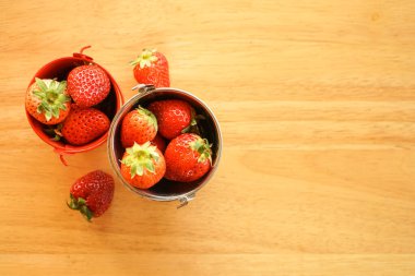 Küçük paslanmaz çelik su kovası içinde taze çilek. 