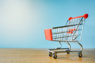 Mavi arkaplanda boş alışveriş arabası ve sol tarafta kopyalama alanı. 