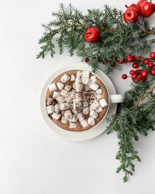 Beyaz zemin üzerinde marşmelov ve köknar ağacı olan kakao ya da kapuçino.