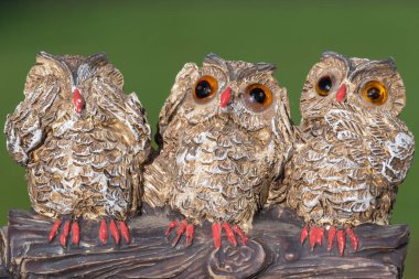 Close up of an ornament of three owls depicting the proverb see no evil hear no evil speak no evil. clipart