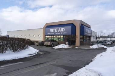UTICA, NEW YORK - MAR 04, 2019: Winter View of Rite Aid Pharmacy Exterior, Located at 1924 Genesee St, Utica, NY 13502. Rite Aid is a Drugstore Chain in the United States. clipart